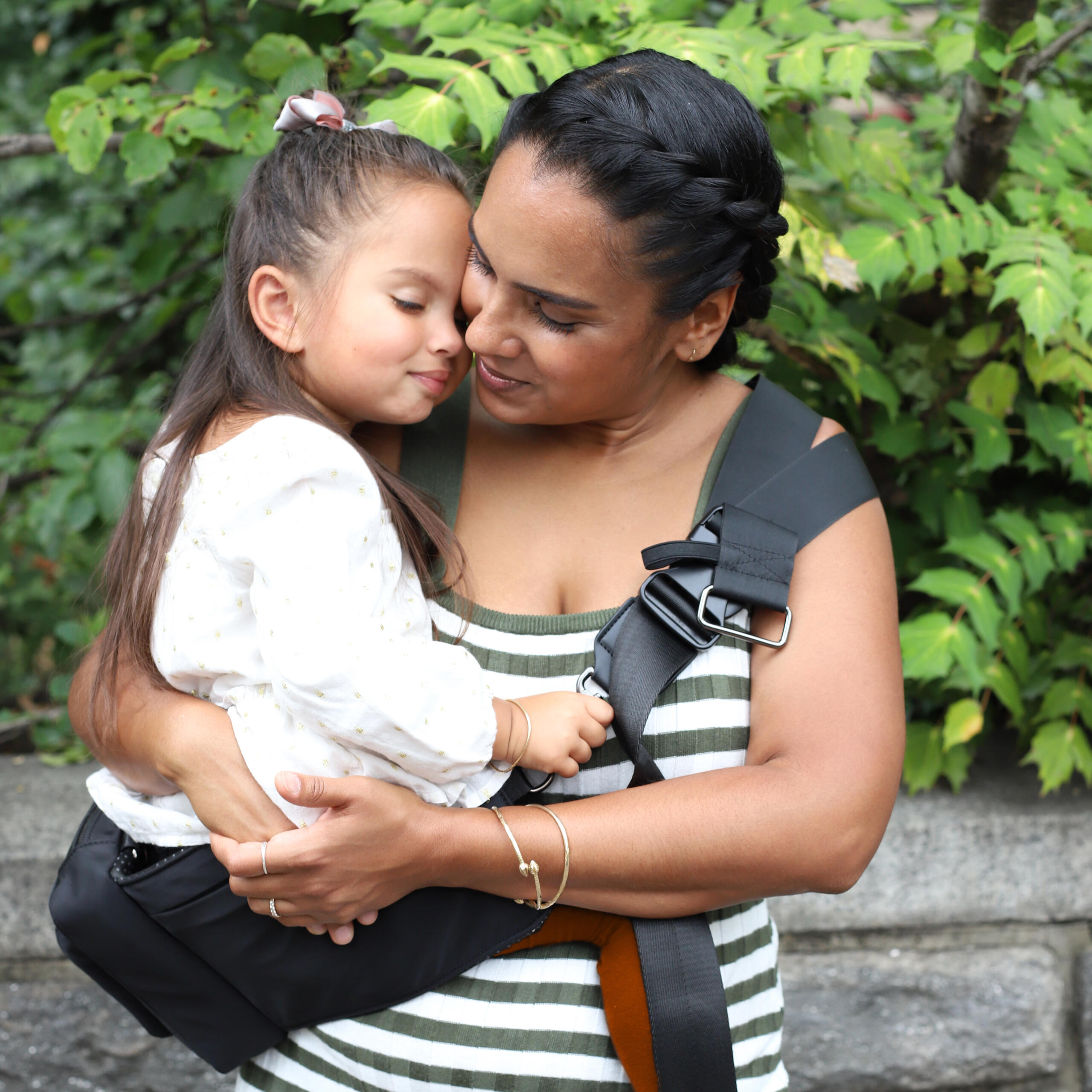 Mom cuddling child who is seated comfortable in the Jacana Perch.